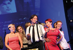 Alessandro Conti, cantante degli Attack-a-boogie, gruppo swing che ha allietato la serata, circondato dalle ballerine di Zenaswingers